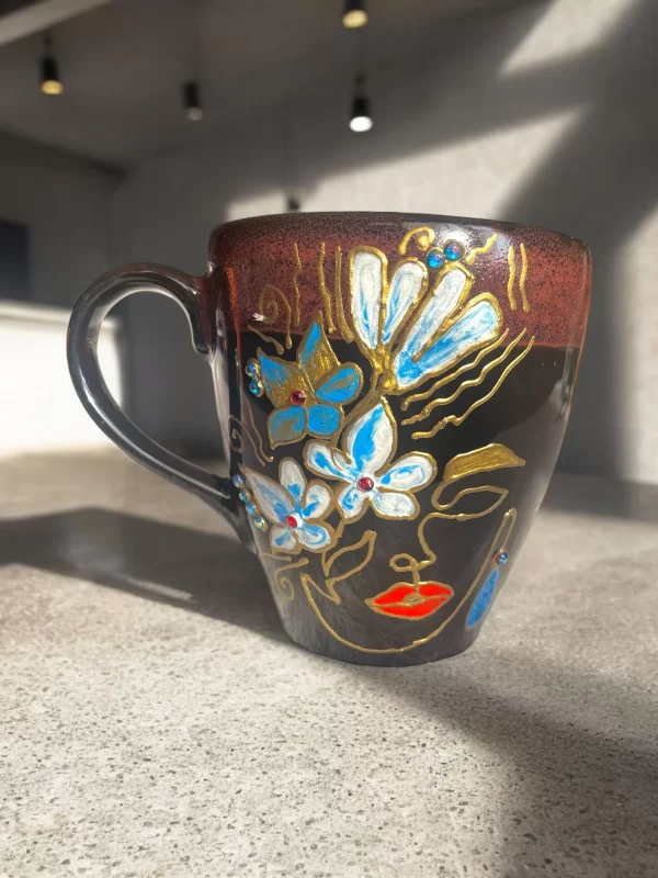 Handcrafted Black Ceramic Face Mug with Blue Floral and Gold Accents